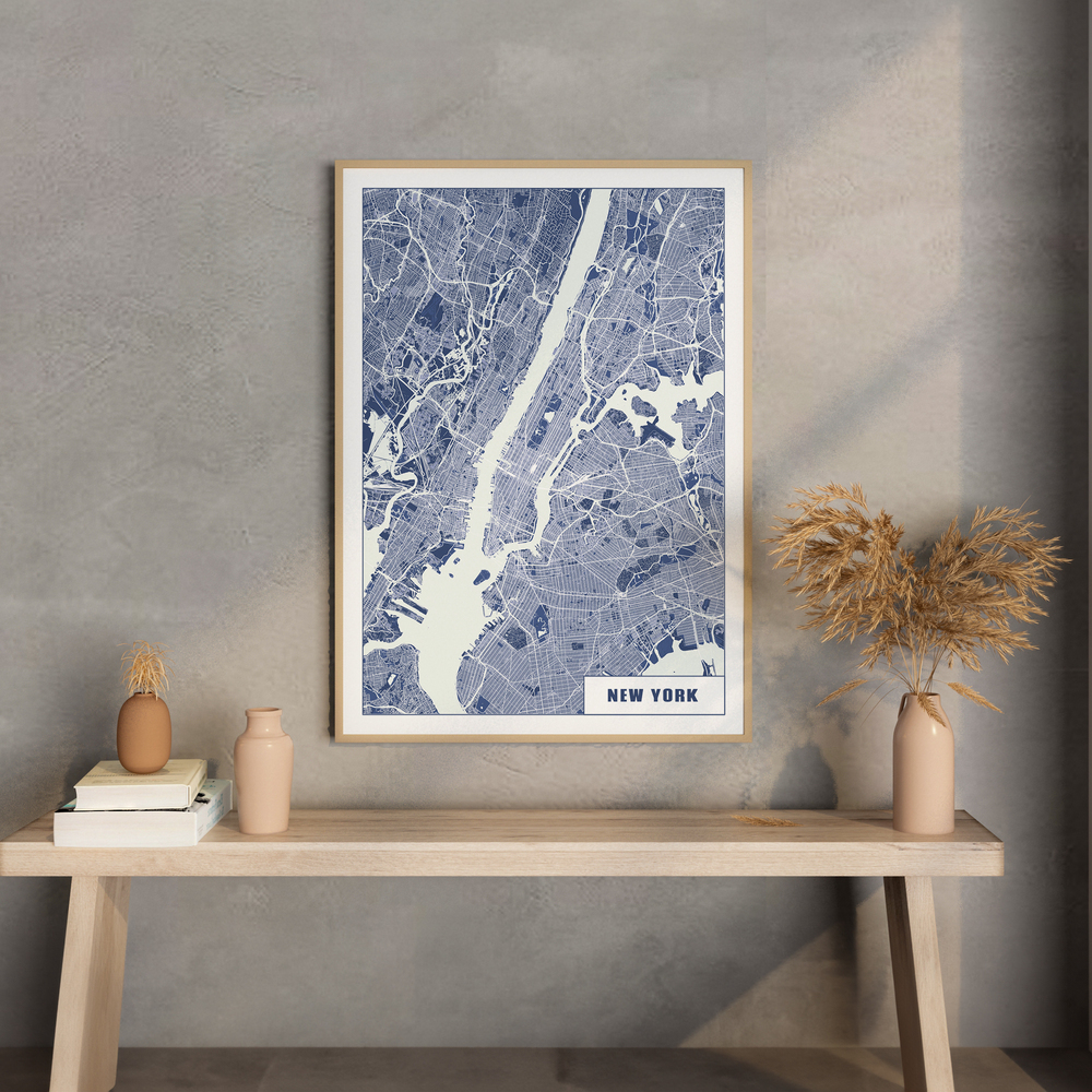 Affiche du plan de New York bleu et blanc, encadrée en bois clair au-dessus d’une console avec des vases