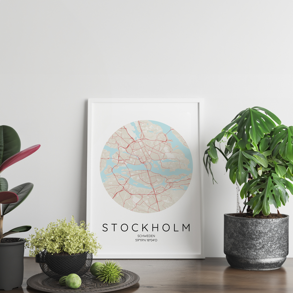 Affiche avec plan circulaire de Stockholm, encadrée en blanc et posée sur un meuble en bois entre des plantes