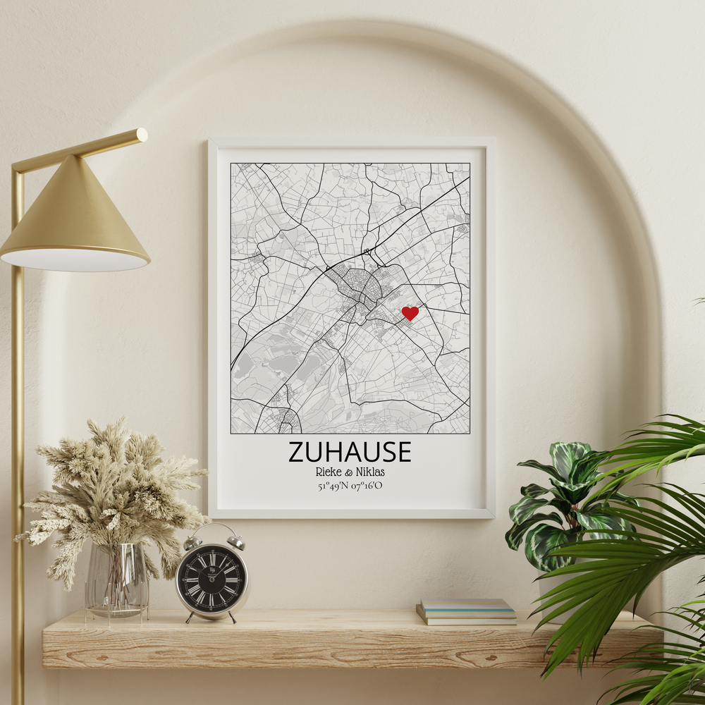 Heimatkarte mit rotem Herz im weißen Rahmen in einer Wandnische als Geschenkidee fürs neue Zuhause
