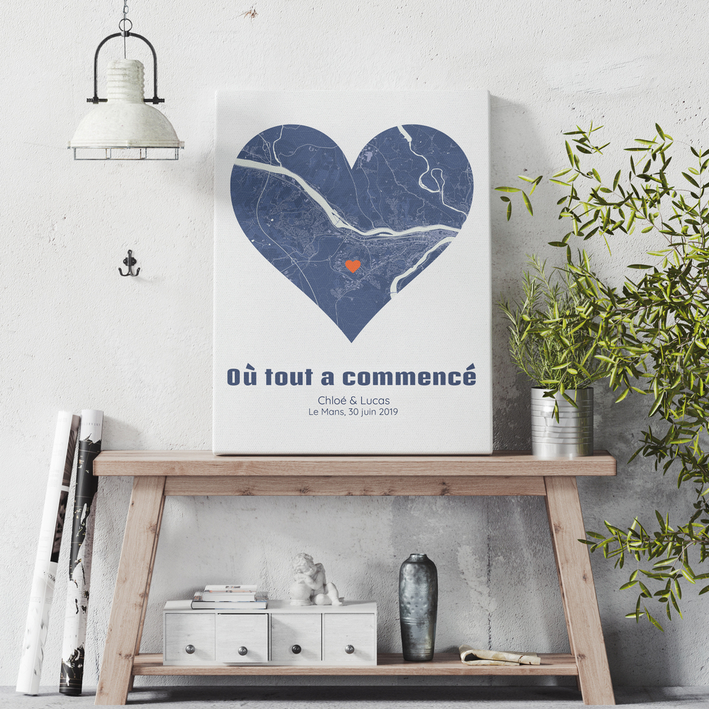 Carte de ville en cœur sur toile posée sur une console en bois, un cadeau pour célébrer un anniversaire de rencontre