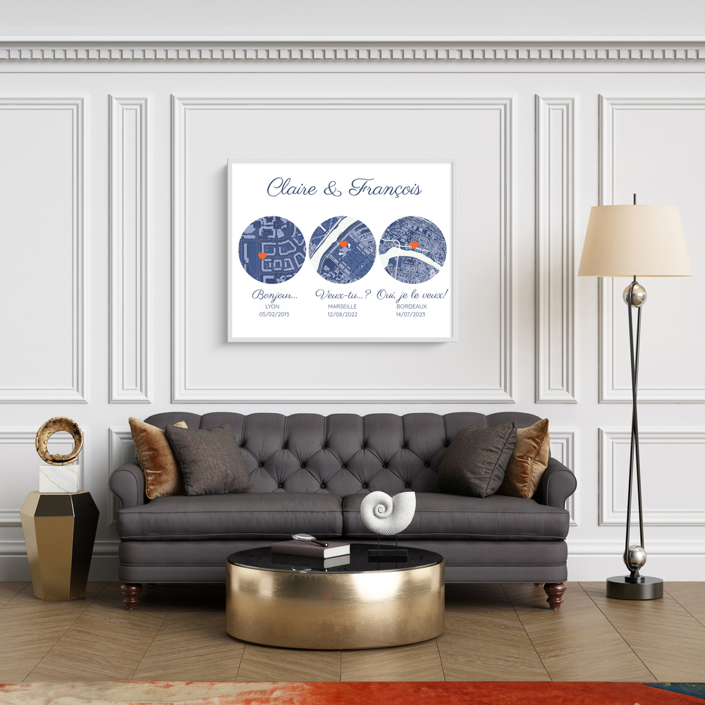 Affiche encadrée en blanc avec trois cartes rondes personnalisées, au-dessus d’un canapé gris dans un salon à moulures